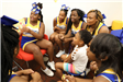 Cheerleaders Reading to Child