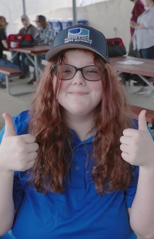 Teenage girl wearing a hat with her thumbs up