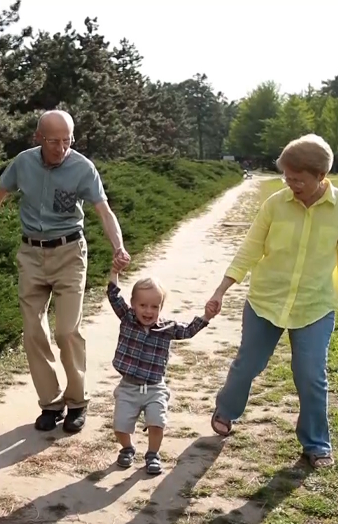 Older woman and man holding hands with a young boy.