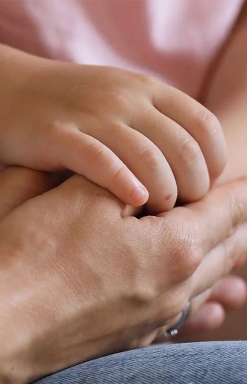 Older hand holding a younger hand